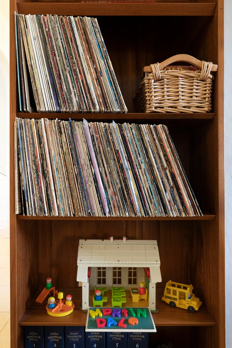 Two shelves of vinyl records above a toy schoolhouse and letters spelling Martindale