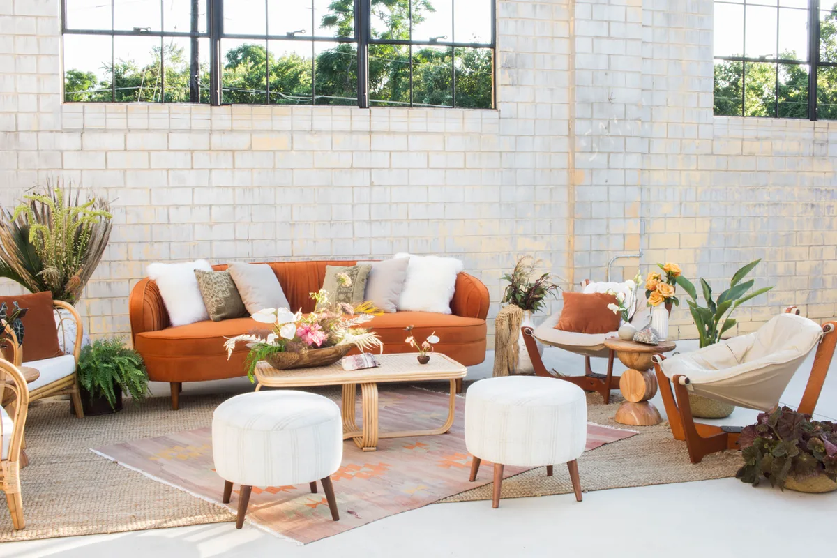 Lounge seating in the Social Hall: burnt orange velvet sofa, rattan coffee table, kilim rugs