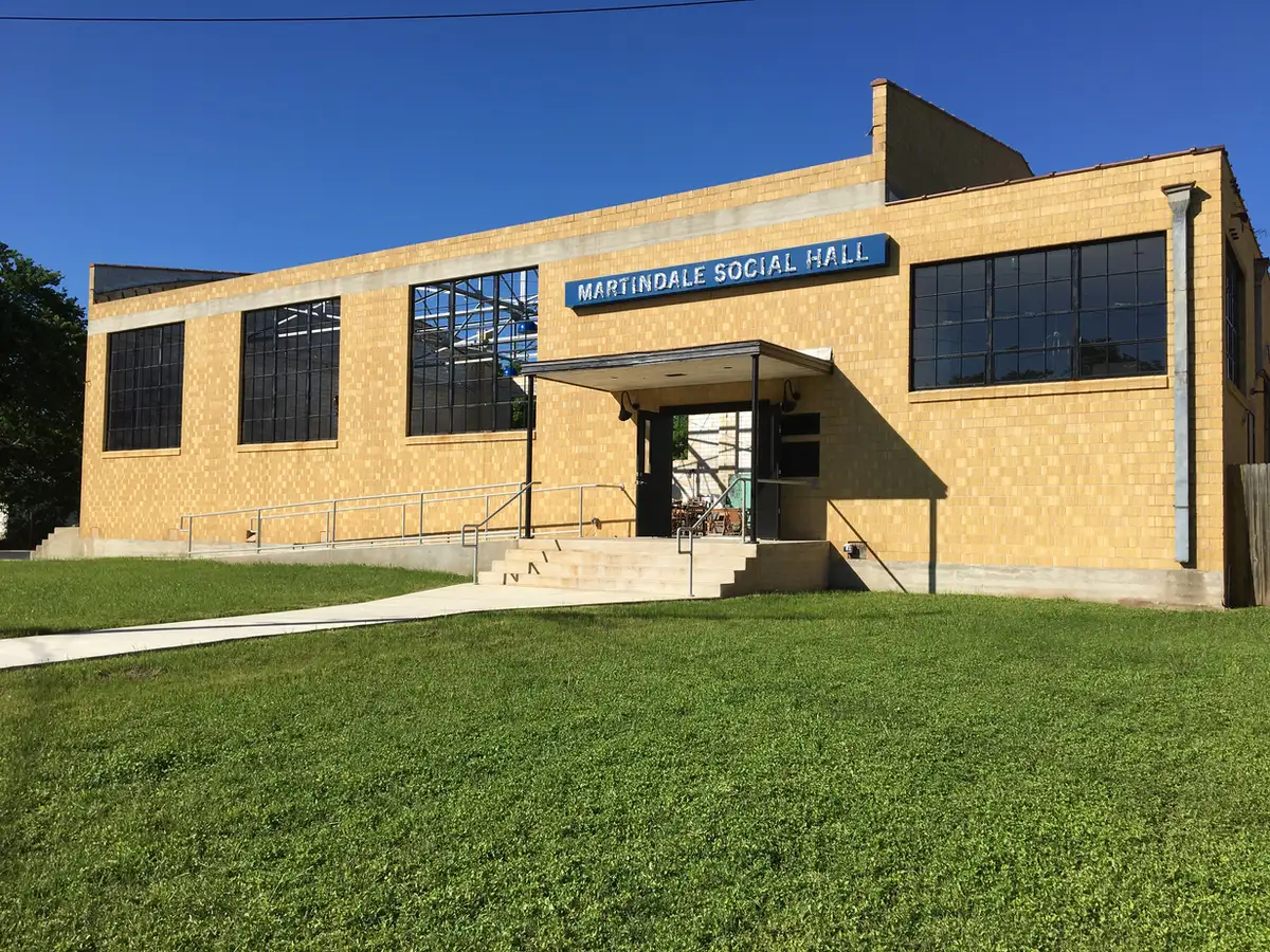 Martindale Social Hall exterior, yellow brick gymnasium with blue sign and steel-framed windows