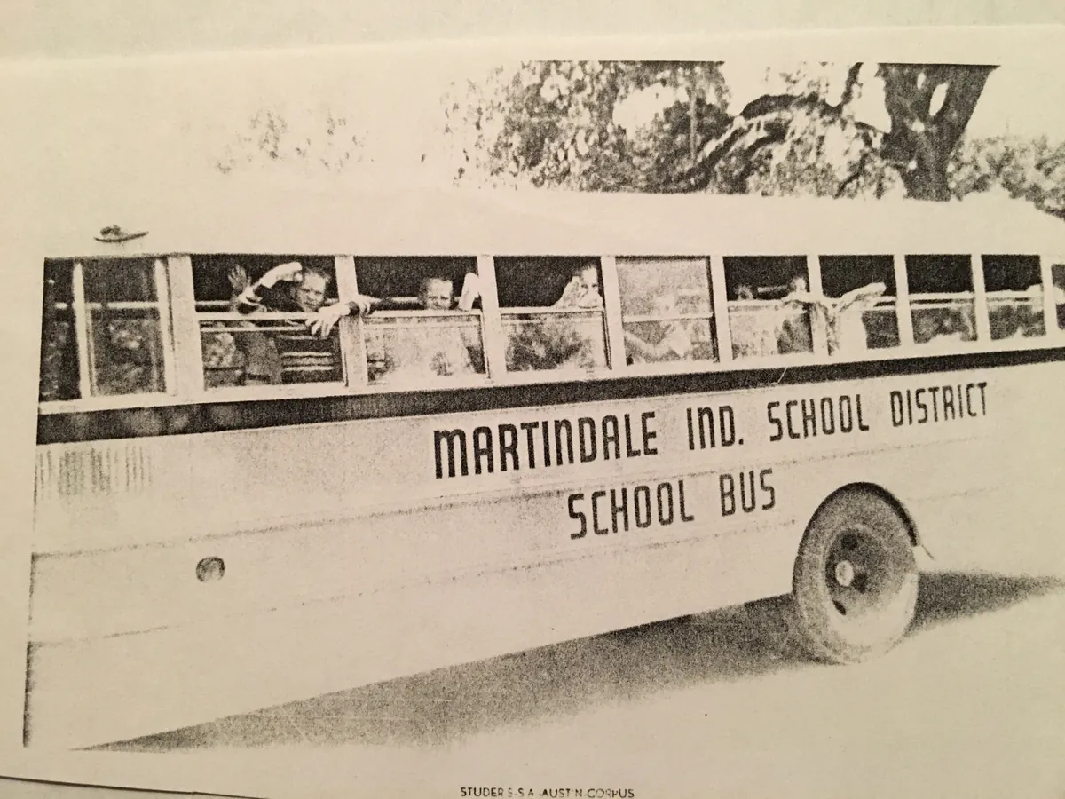 Vintage black and white photo of the Martindale Ind. School District school bus, children waving from the windows